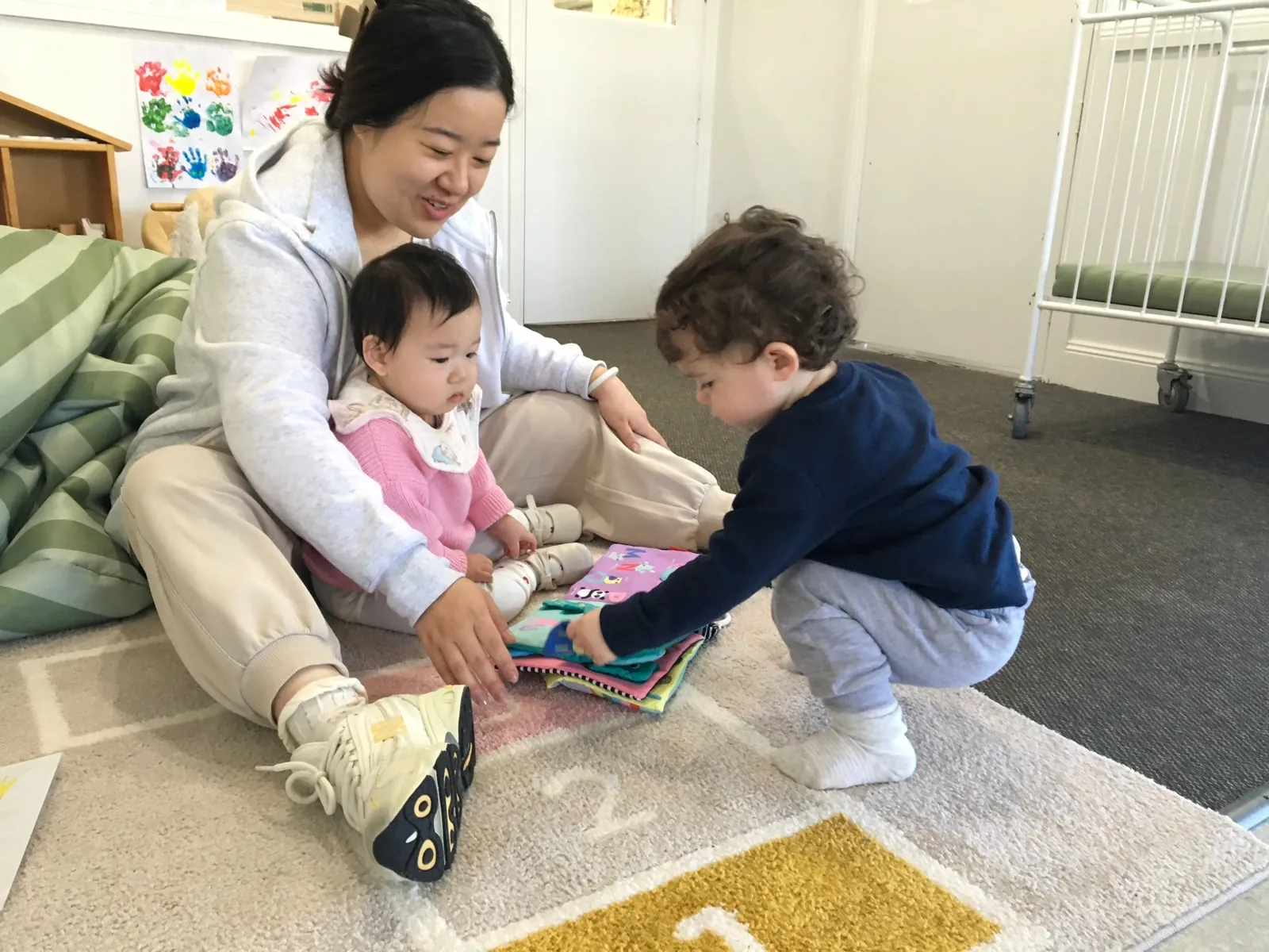 Educator warmly engaging with babies during sensory play in the Little Sharkies Baby Room
