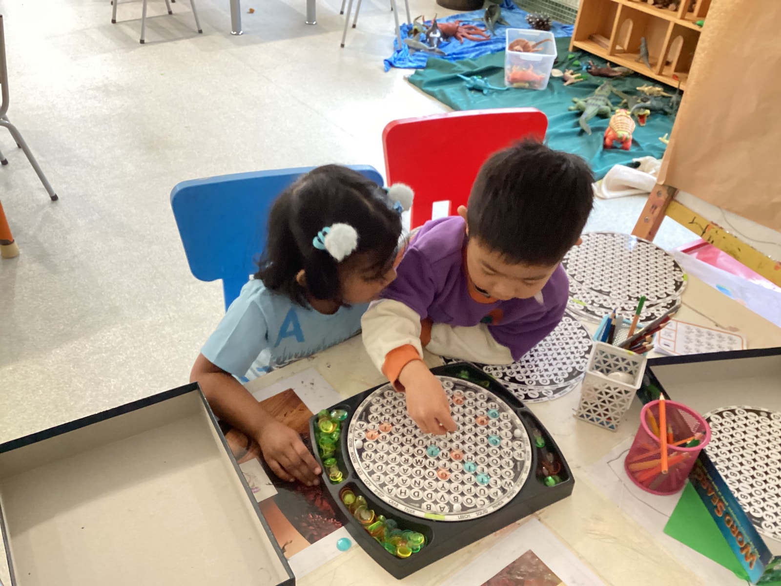 Two children exploring a letter puzzle together at a table