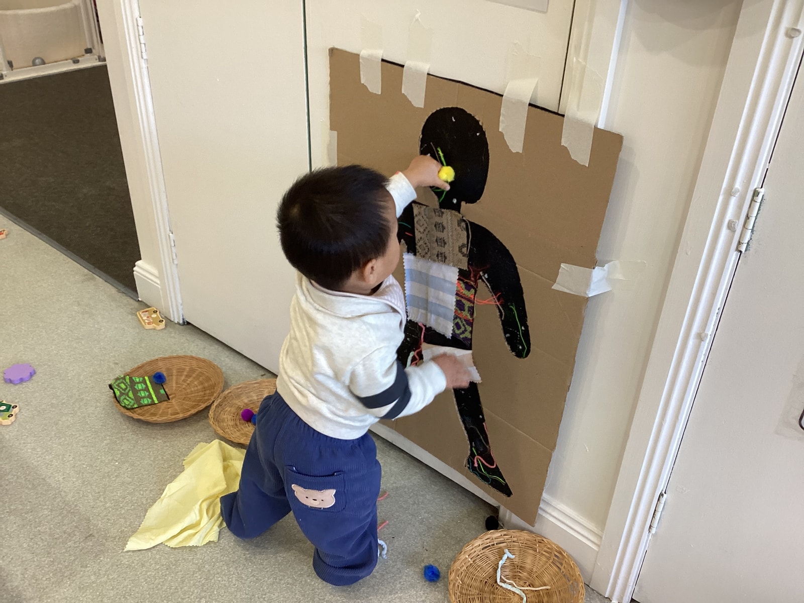 Child decorating a large fabric silhouette artwork